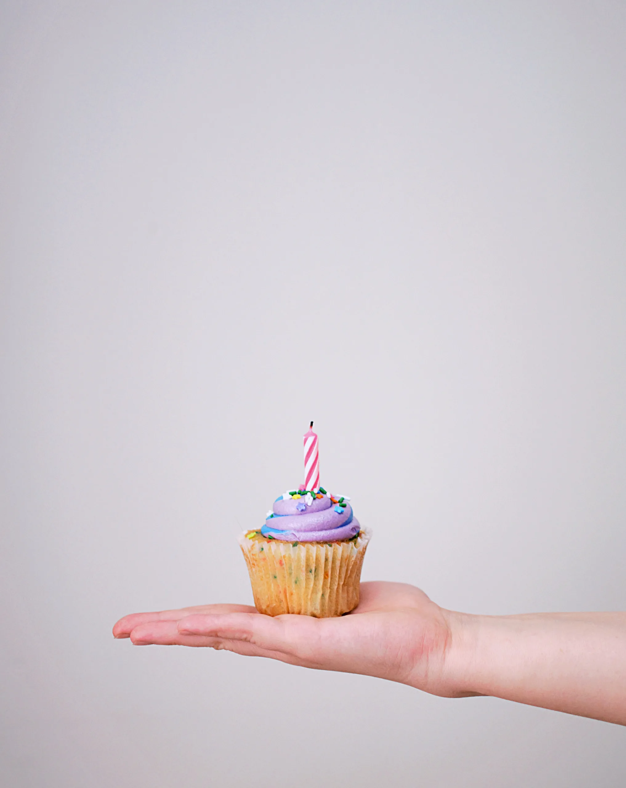 Individual cupcake with birthday candle for safe celebrating during Covid-19 pandemic